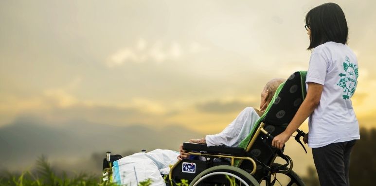 Osoba na wózku wraz z osobą towarzyszącą patrzące na niebo.
