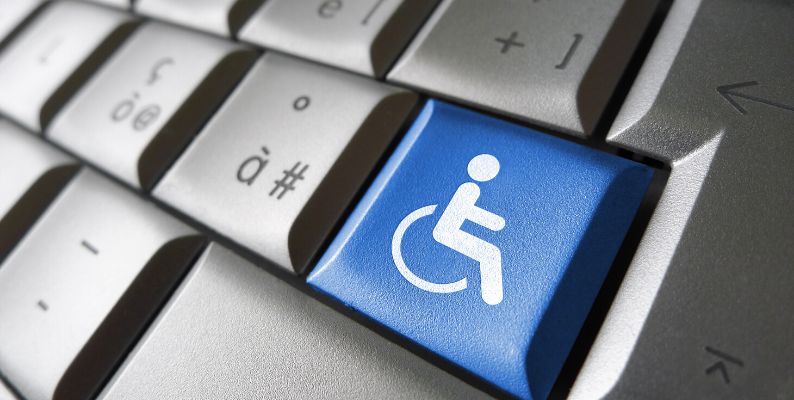 Fragment klawiatury komputerowej. Na jednym klawiszu, w kolorze niebieskim symbol osoby na wózku.