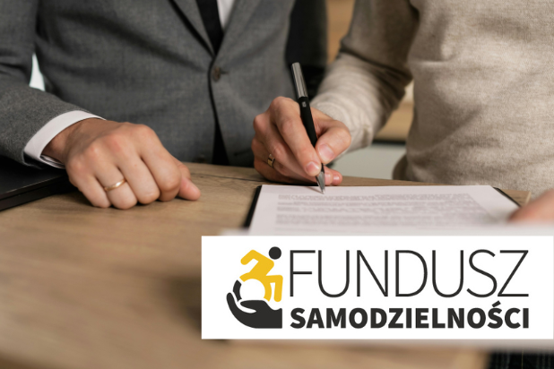 Ręce dwóch osób, jedna z nich trzyma długopis i podpisuje dokument. W prawym dolnym rogu logo Funduszu Samodzielności